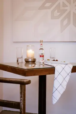 a bottle of whiskey and a candle on a table at Utopia Luxury Suites - Old Town in Rhodes Town