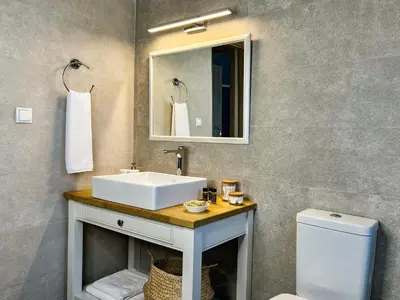 a bathroom with a sink and a mirror and a toilet at PETRA RESIDENCES IN LINDOS in Líndos
