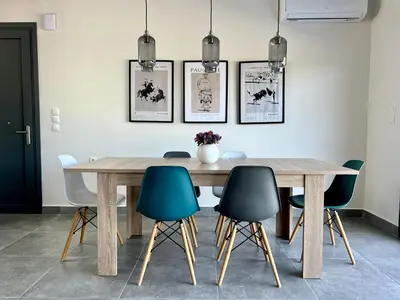 a dining room with a wooden table and chairs at PETRA RESIDENCES IN LINDOS in Líndos