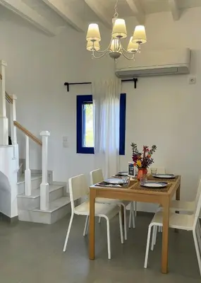 a dining room with a wooden table and chairs at Ktima Tzaneti - Coastal Farmhouse in Lachania