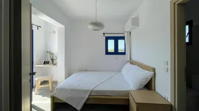 a bedroom with a bed in a white room at Ktima Tzaneti - Coastal Farmhouse in Lachania