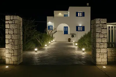 a building with lights on a street at night at Ktima Tzaneti - Coastal Farmhouse in Lachania