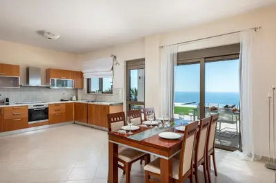 a kitchen and dining room with a table and chairs at Diamond Hill Villa in Koskinou