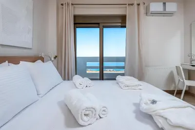 a bedroom with a white bed with towels on it at Diamond Hill Villa in Koskinou