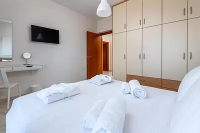 a white bedroom with white towels on a bed at Diamond Hill Villa in Koskinou