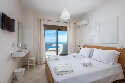 a bedroom with a bed with a view of the ocean at Diamond Hill Villa in Koskinou