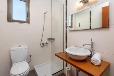a bathroom with a toilet and a sink and a shower at Diamond Hill Villa in Koskinou