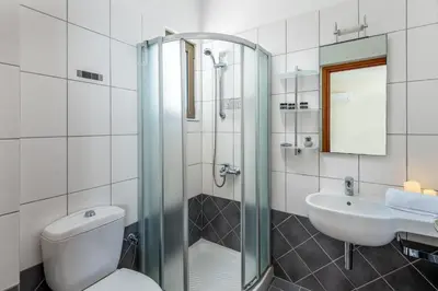 a bathroom with a shower and a toilet and a sink at Diamond Hill Villa in Koskinou