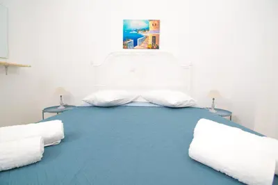 a bedroom with a large white bed with two pillows at CHAMBRE BLANCHE in Ialyssos