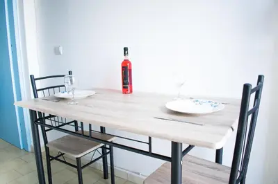 a wooden table with two chairs and a fire extinguisher at CHAMBRE BLANCHE in Ialyssos