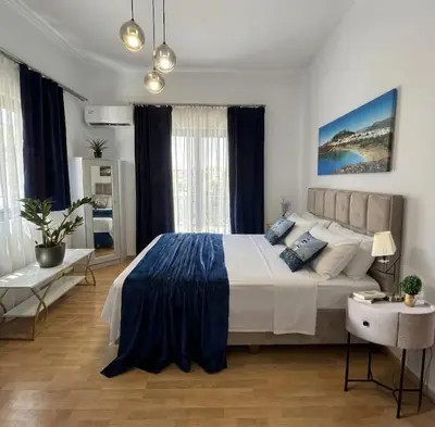 a bedroom with a large bed and a table at Antonia's Apartments in Archangelos
