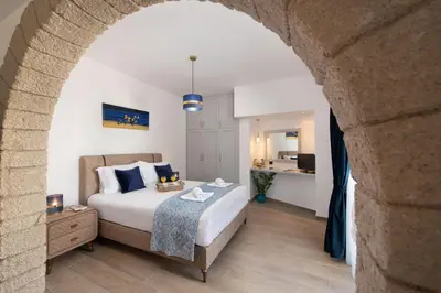 a bedroom with a bed in a room with an arch at Antonia's Apartments in Archangelos