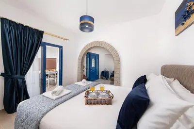 a bedroom with a bed with a tray of food on it at Antonia's Apartments in Archangelos