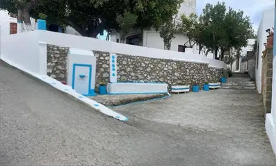 a row of blue benches in front of a wall at Antonia's Apartments in Archangelos
