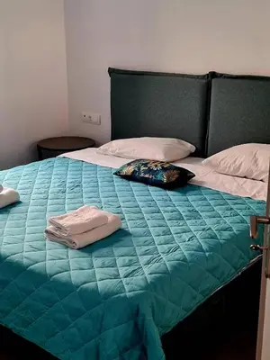 a bed with a blue comforter and two pillows on it at Rhodes Comfort Luxury Apartment in Rhodes Town