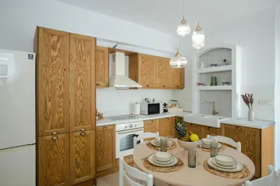 a kitchen with a table and a white refrigerator at AENAON in Archangelos