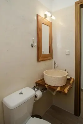 a bathroom with a sink and a toilet and a mirror at AENAON in Archangelos