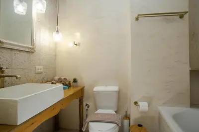 a bathroom with a sink and a toilet and a tub at AENAON in Archangelos