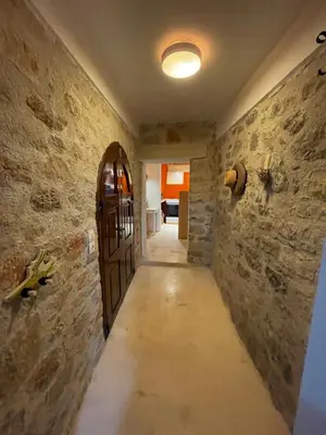 a hallway with a door in a stone wall at villa Elpiniki Tilos in Megálon Choríon