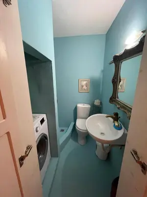 a blue bathroom with a sink and a washing machine at villa Elpiniki Tilos in Megálon Choríon