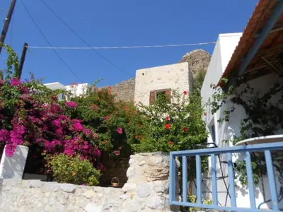 a building with flowers on the side of it at villa Elpiniki Tilos in Megálon Choríon