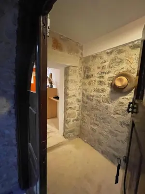an open door to a room with a stone wall at villa Elpiniki Tilos in Megálon Choríon