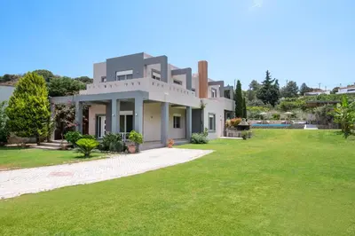a house with a green lawn in front of it at GGA Albatross Villa in Afantou