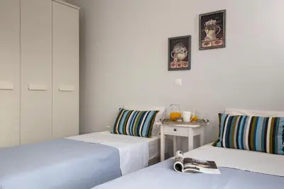 a room with two beds and a table with a magazine at Thalassa Luxury Villa in Ialyssos