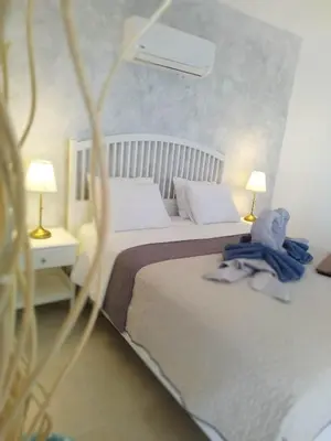 a bedroom with a bed with a teddy bear on it at Villa Leonardo in Archangelos