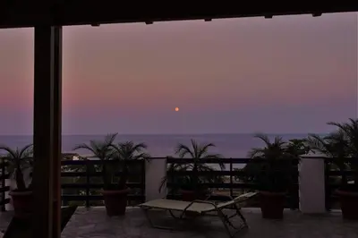 a view of the ocean at sunset from a balcony at Villa Leonardo in Archangelos