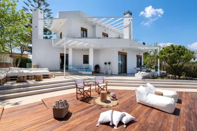a house with white furniture on a wooden deck at Love White Villa in Ialyssos