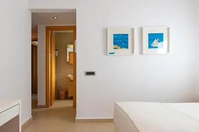 a white bedroom with two pictures on the wall at Love White Villa in Ialyssos