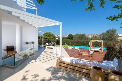 a backyard with a wooden deck with a pool at Love White Villa in Ialyssos