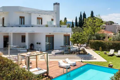 a villa with a swimming pool and a house at Love White Villa in Ialyssos