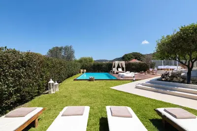 a backyard with a swimming pool and lawnitures at Love White Villa in Ialyssos