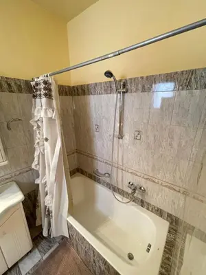 a bathroom with a bath tub and a shower at Elia Old Mansion in Malona Village