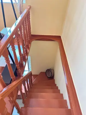 a stairway with a wooden rail and a hat at Elia Old Mansion in Malona Village