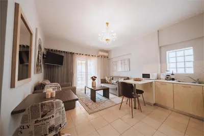 a living room and kitchen with a couch and a table at Iliotti Apartments in Rhodes Town