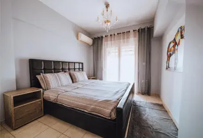 a bedroom with a bed and a chandelier at Iliotti Apartments in Rhodes Town