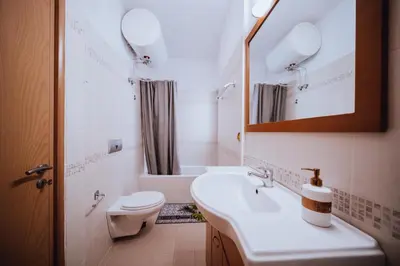a bathroom with a sink and a toilet and a mirror at Iliotti Apartments in Rhodes Town