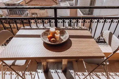 a bowl of fruit and candles on a table on a balcony at Iliotti Apartments in Rhodes Town