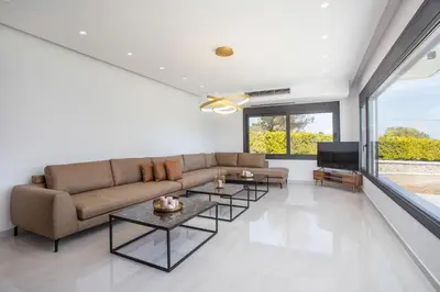a living room with a couch and a tv at Villa Indira in Kalithies