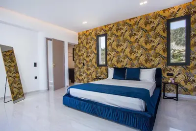 a bedroom with a bed with a blue and yellow wall at Villa Indira in Kalithies