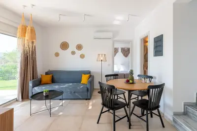 a living room with a table and chairs and a couch at OSSIANO POOL VILLAS, Heating Pool, 2 min drive to Haraki Beach & 10 to Lindos in Haraki