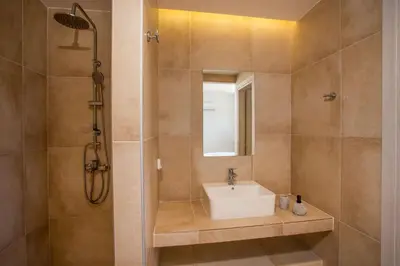 a bathroom with a sink and a shower at OSSIANO POOL VILLAS, Heating Pool, 2 min drive to Haraki Beach & 10 to Lindos in Haraki