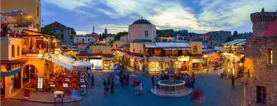 a group of people walking around a city street at OSSIANO POOL VILLAS, Heating Pool, 2 min drive to Haraki Beach & 10 to Lindos in Haraki