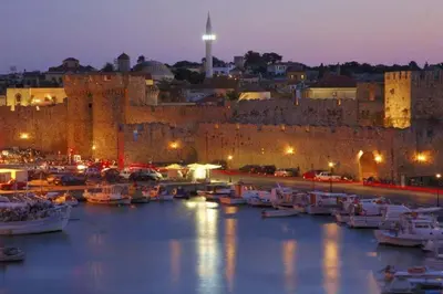 a harbor with boats in the water in front of a castle at OSSIANO POOL VILLAS, Heating Pool, 2 min drive to Haraki Beach & 10 to Lindos in Haraki