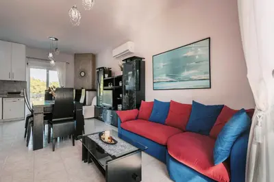 a living room with a red and blue couch at Greek Style Apartment with Jaquzzi & Barbeque in Triánta