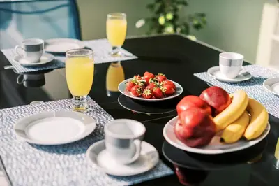 a table with plates of fruit and glasses of orange juice at Greek Style Apartment with Jaquzzi & Barbeque in Triánta