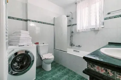 a bathroom with a washing machine and a sink at Greek Style Apartment with Jaquzzi & Barbeque in Triánta
